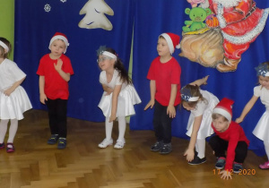 Dzieci tańczą na występie choinkowym.