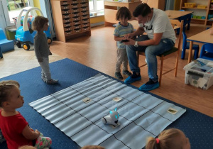 Dzieci z gr I uczestniczą w zajęciach z robotyki. Programują robota.