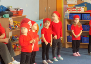 Dzieci przebrane za krasnoludki tańczą i śpiewaja
