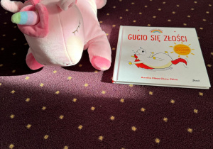 Zdjęcie pluszowego jednorożca i książki